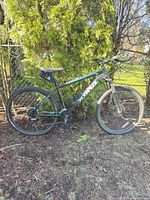 Full side view of Kona mountain bike showing frame, wheels, suspension fork, saddle bag