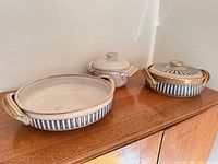All three Melling pieces on cabinet: lidded casserole, shallow baker, small lidded pot