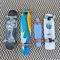 Four skateboards top view showing deck graphics and wheel types