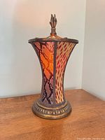 Front view of bronze table lamp on wood surface