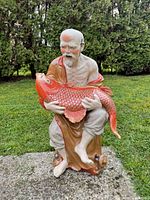 front view of porcelain fisherman holding koi