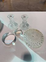 Two candlesticks, two paperweights, one hobnail coaster visible