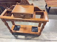 Full view of carved oak hall umbrella stand showing drawer closed and overall structure