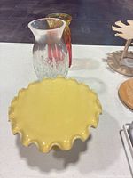 All three items grouped: yellow cake stand front, clear glass vase and ombre vase behind