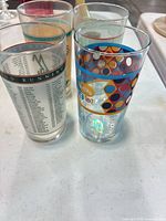 Front view of four pint glasses showing designs
