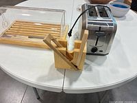 Hamilton Beach toaster, acrylic bread box on wood tray, wooden slicing guide on tabletop