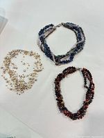 Group shot of all three necklaces laid flat