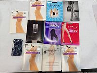 Nine boxed pantyhose and one poly-bag pair displayed on table