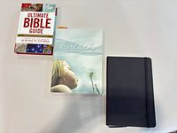 All three items—Bible guide, "breathe" reader, black notebook—laid flat