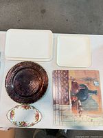 All items grouped: three off-white trays, hammered metal charger, four placemats, oval floral dish