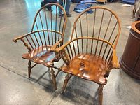 Front angled view of both Windsor spindle-back armchairs showing overall design, finish and wear