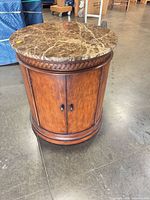Front angle showing marble top, wood body, cabinet doors