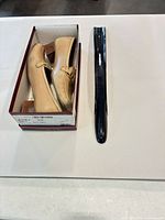 Shoes in Ferragamo box beside black shoehorn