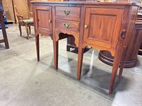 Front view showing doors, drawers, legs, hardware