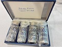 Set of four cordial glasses in holders inside presentation box with note card