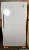 Front view of white upright freezer showing full exterior and handle