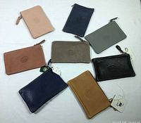 All eight Roots leather zip pouches displayed to show colours and overall condition