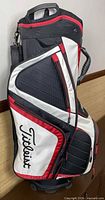 Left side view showing pockets, shoulder strap and Titleist logo