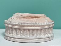 Side view showing covered dish exterior, relief pattern and lid
