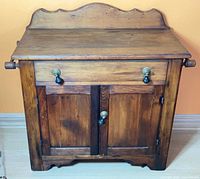 Front view of wooden wash stand showing overall design and hardware