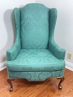Front view of teal wingback chair showing overall design