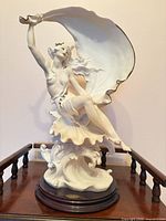 Full view of porcelain figurine on wood base