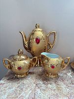 coffee pot, sugar bowl, creamer showing gold finish and rhinestones