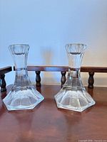 Two Mikasa Opera crystal candle holders standing on wooden surface