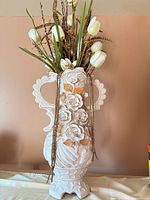 Full view of ornate cream ceramic vase with faux floral arrangement