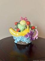 Front view of ceramic fruit basket teapot with banana spout and fruit lid