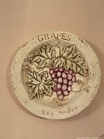Raised-relief ceramic plaque with grapes design and inscription