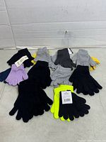 Group of knit gloves in assorted colours laid out