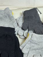 Multiple pairs of grey, black and dark grey knit gloves