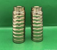 Front view of two identical ribbed metal candle holders