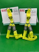 Front view of two packaged yellow LED dog harnesses