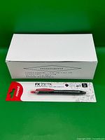 Closed white box labeled Monami FX ZETA/1B and one blister-packed pen