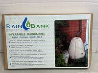 Retail box front showing Rain Bank inflatable rain barrel branding and specifications