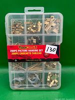 Front view of sealed ToolDeal 200-piece picture hanging set in clear organizer