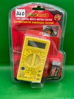 Front view of sealed package showing multimeter and battery