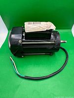 Side view of motor showing housing, mounted rods, wiring