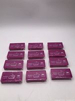 All 12 sealed purple packs arranged in rows