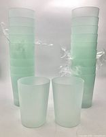 Stacked set of 20 light green plastic tumblers
