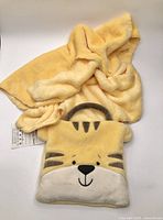 Blanket partially unfolded with carry pouch showing tiger face