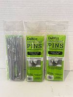 Front view of three sealed DeWitt anchoring pin packs