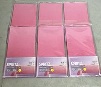 Front view of six packaged Spritz pink ombre table covers