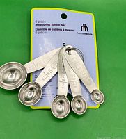 Front view of 5-piece stainless steel measuring spoon set on card