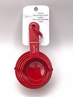 Front view of nested red measuring cups with Mainstays tag