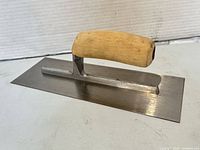 Top view of trowel showing wood handle and steel blade