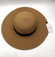 Top view of tan straw sun hat with tag attached