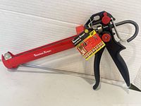 Full view of red Tooltech Xpert 9" caulking gun with tag